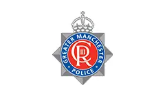 Official logo of Greater Manchester Police, featuring a silver-grey star badge with a red circular emblem and a crown.
