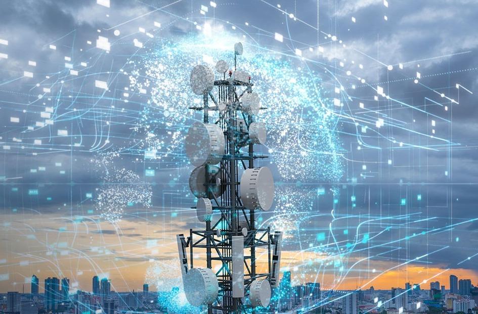 A telecommunications tower with numerous antennas, surrounded by digital data graphics, set against a cityscape and cloudy sky at sunset.